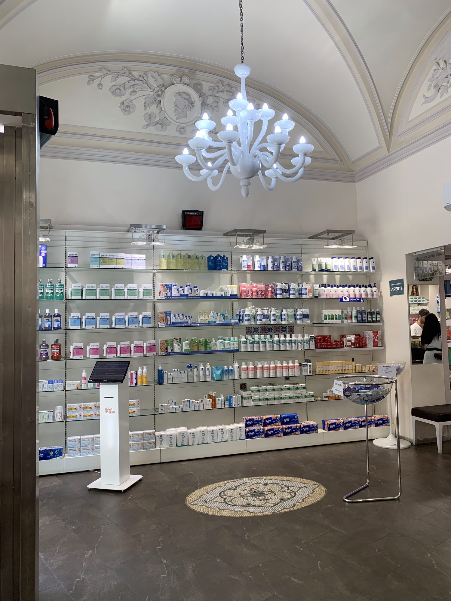 L&rsquo;interno della Farmacia Cairoli, con la volta a padiglione e il lampadario