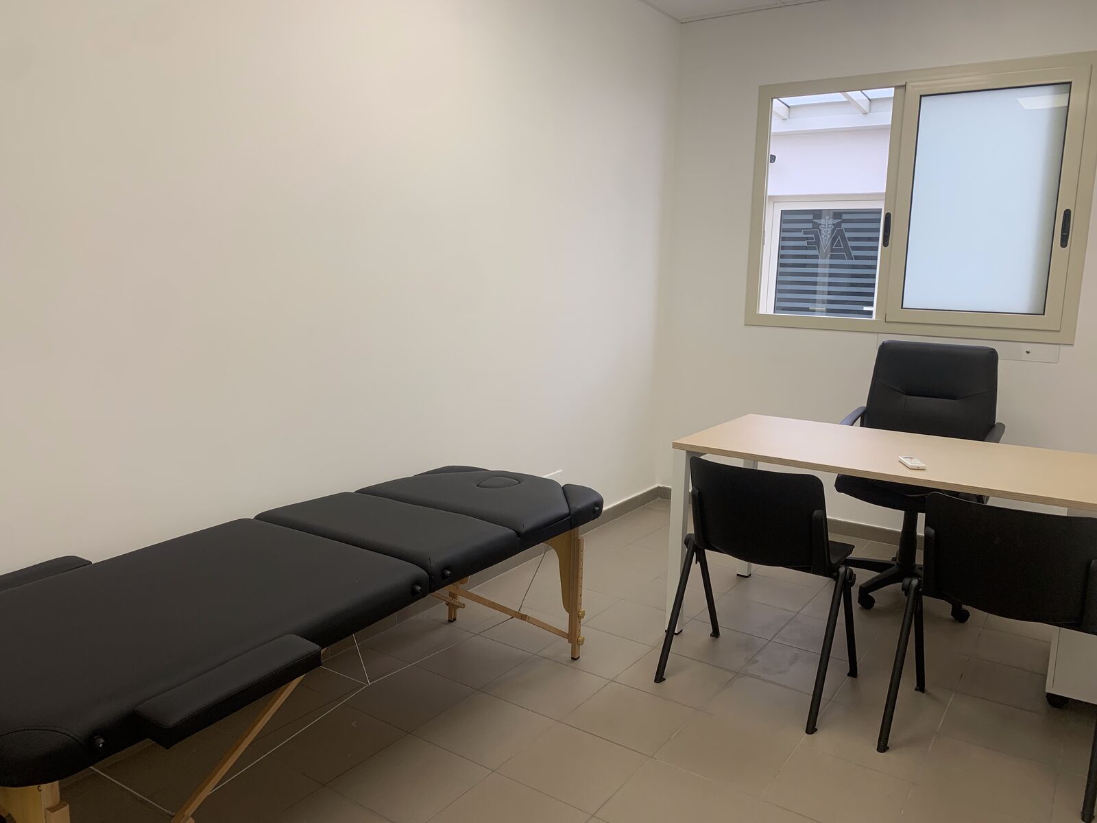 Stanza dell’area servizi con lettino, scrivania e sedie